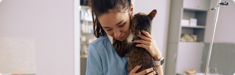 Voluntária abraçando um gato