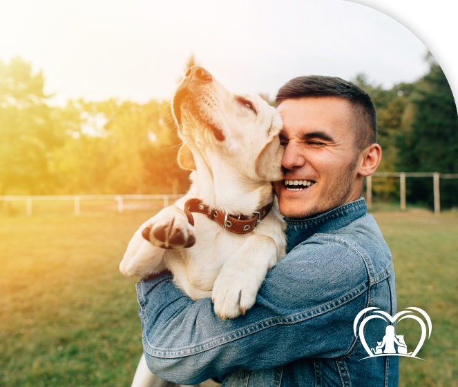 Homem abraçando um cachorro em um campo